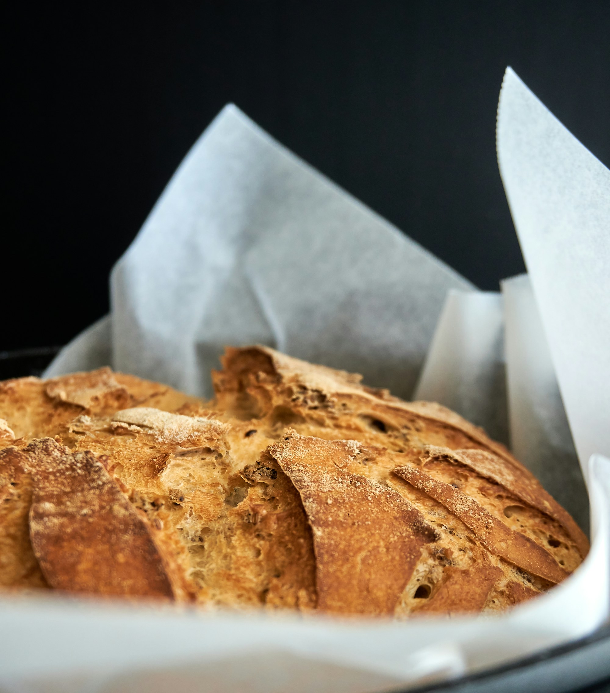 Versgebakken ambachtelijk brood met knapperige goudbruine korst, sfeervol belicht